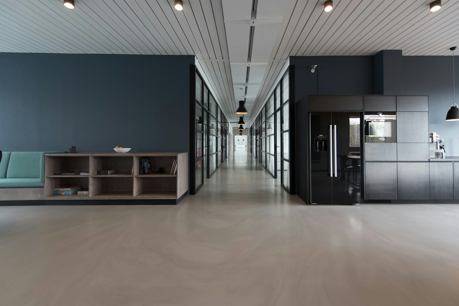An engineering studio workspace with a concrete floor and glass meeting rooms