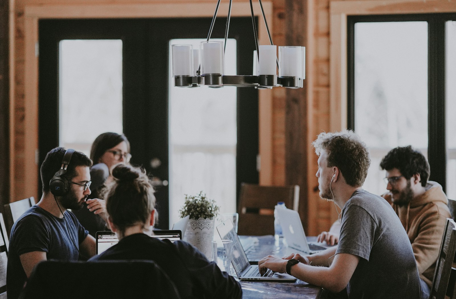 A small team working together around a table in a wood-panelled studio
